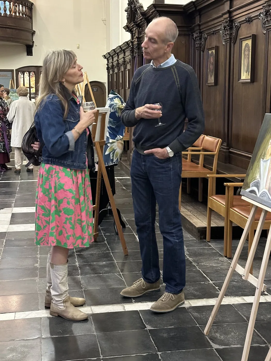 Twee bezoekers in gesprek tussen de tentoongestelde kunstwerken